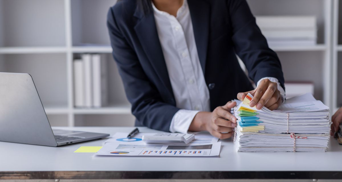 Business,Employee,Asian,Woman,Hand,Working,In,Stacks,Paper,Files