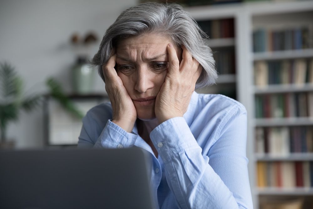 Frustrated,Senior,Retired,Woman,Touching,Head,,Looking,At,Laptop,Screen