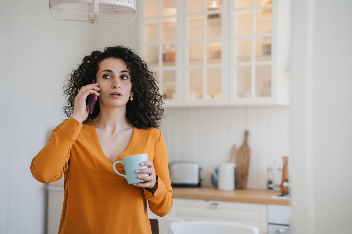 Surprised,Woman,Talking,Phone,At,Home,With,Puzzled,Face,Expression